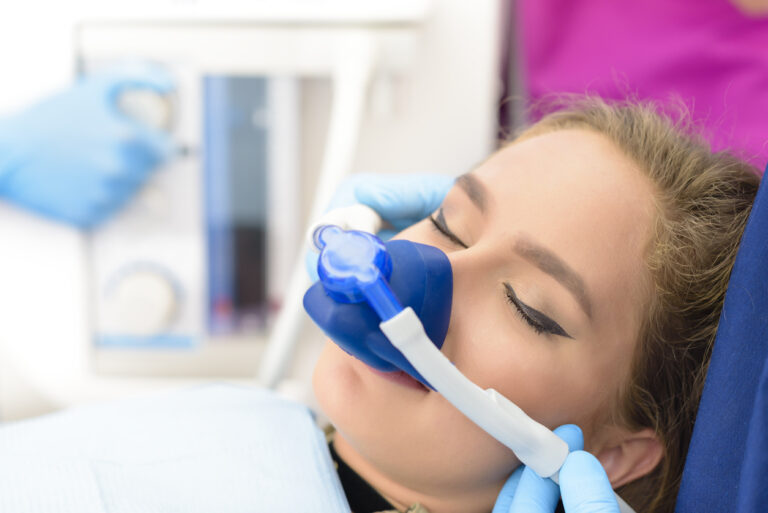 Beautiful woman getting inhalation sedation at dental clinic