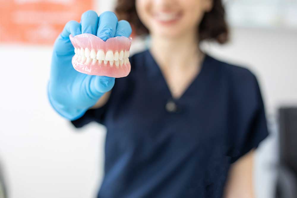 a dentist holding a denture