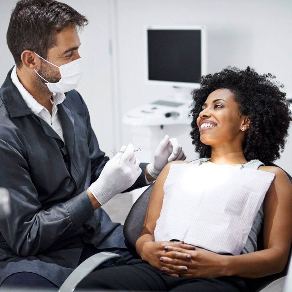 woman on a dental chair talking to a dentist about oral health