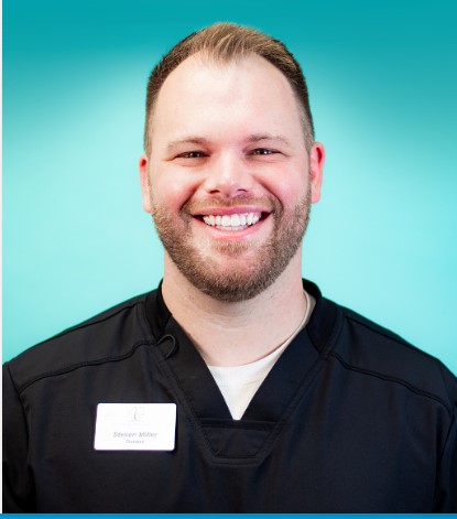 Dr. Steven Miller smiling while wearing a black scrub suit